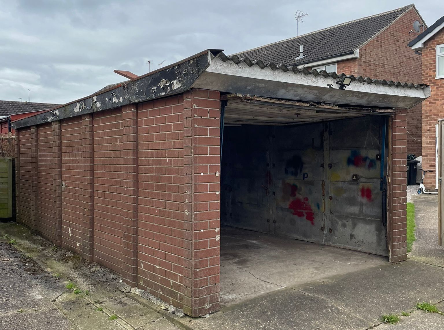 A brick built garage with an asbestos roof