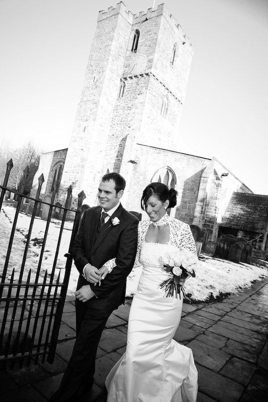 bride and groom walking down church path laughing in county durham and photographed by local photographer kate mitford from mitford photography