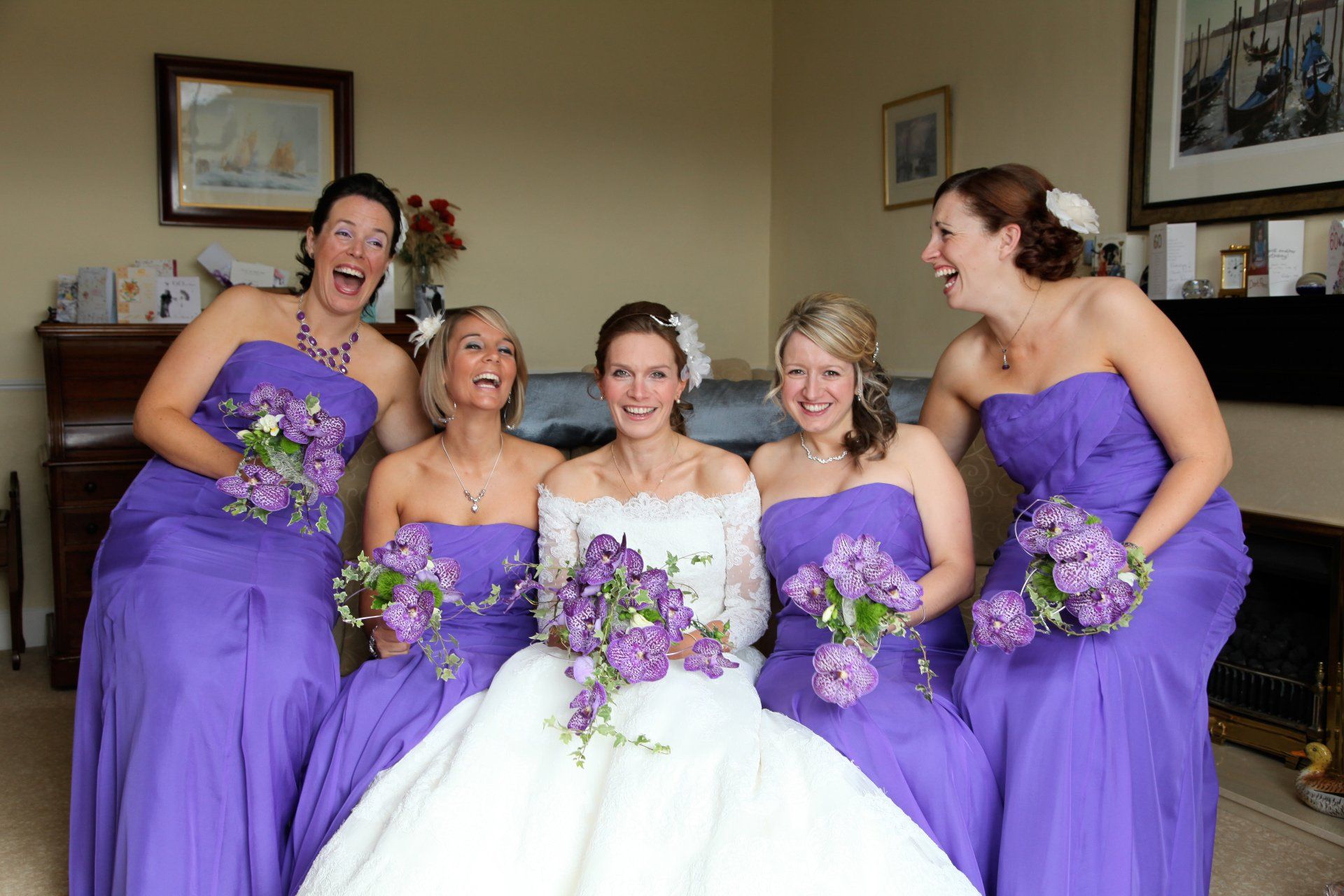 bride and bridesmaids laughing and looking at kate mitford, wedding photographer in the north east of england