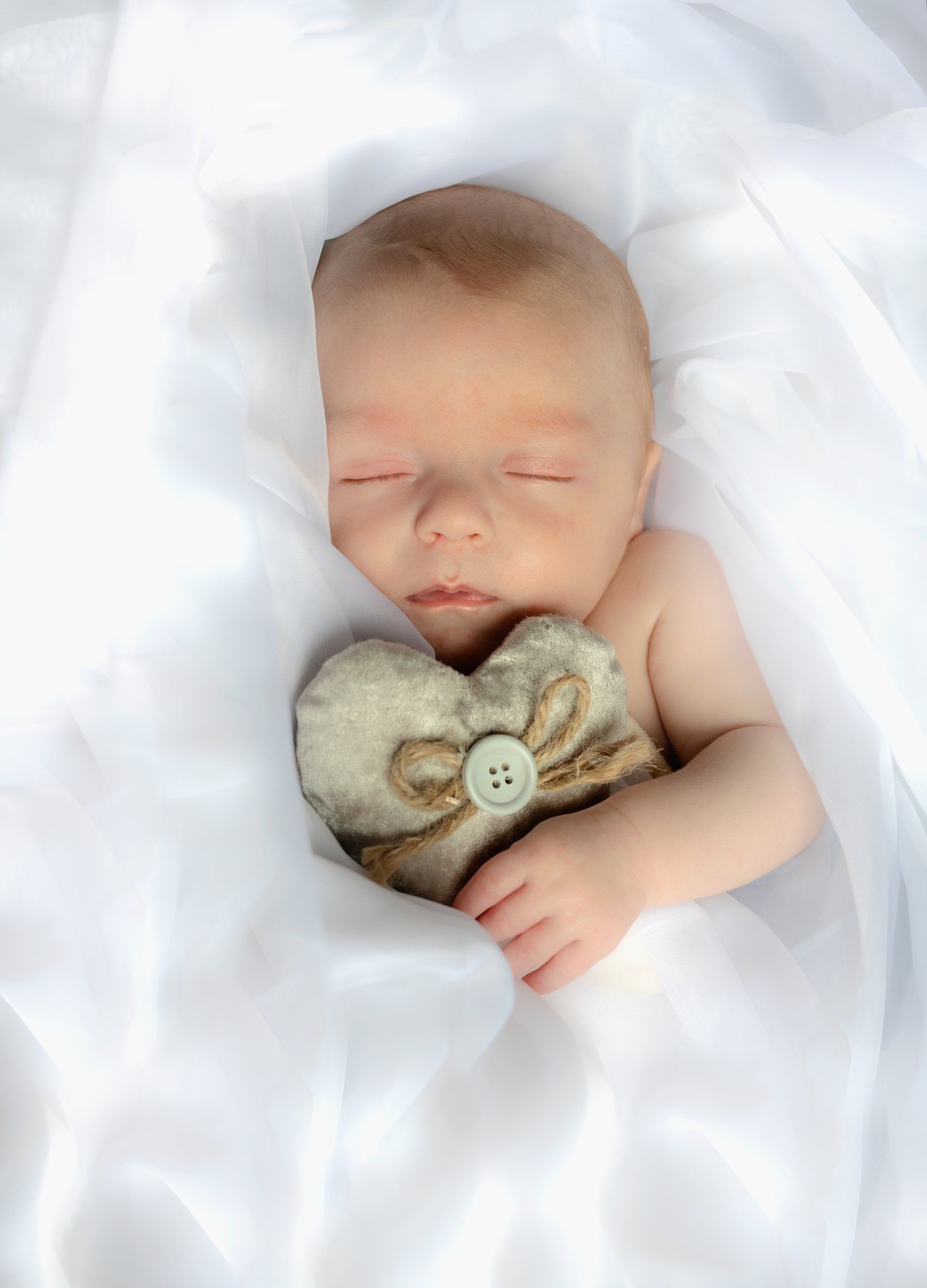 Newborn baby holding a heart on photo session in Darlington