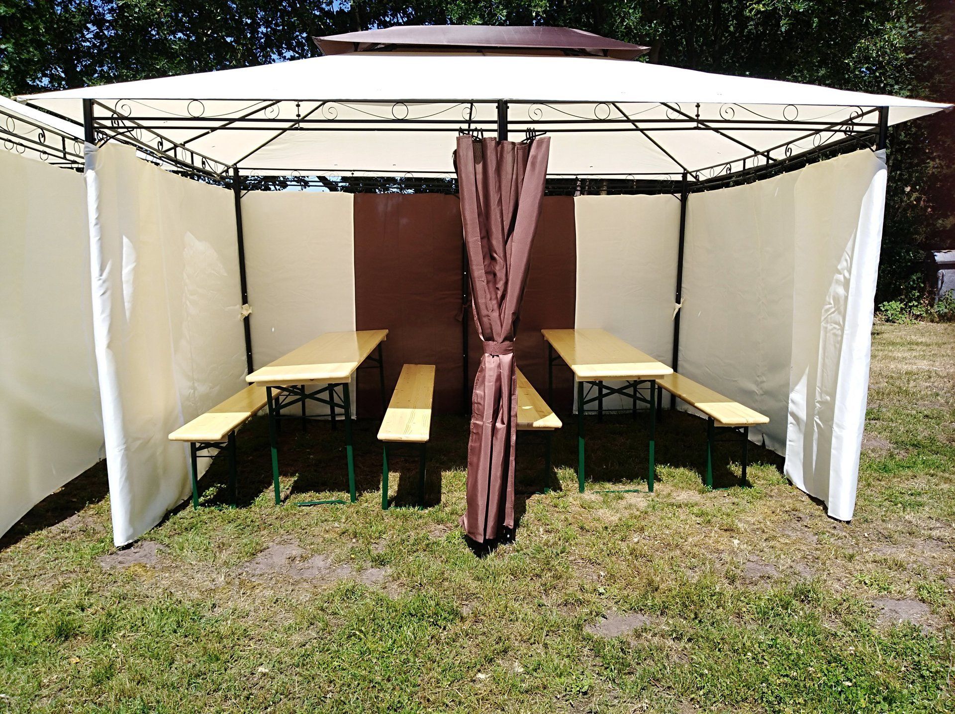 Grillplatz mit zwei Bierzeltgarnituren im Grünen mit Blick auf den See