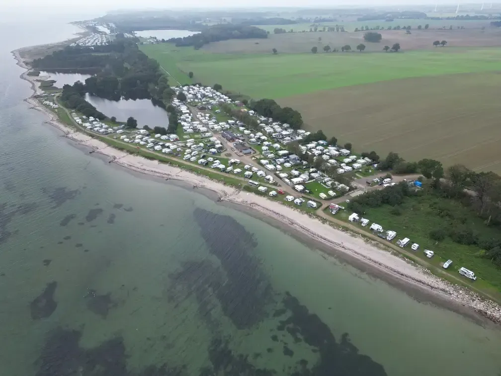 Luftbild des Ostseecamp Lehmberg, dem malerischen Wohnwagen Campingplatz direkt an der Ostseeküste in Waabs, Schleswig-Holstein. Entdecken Sie die perfekte Mischung aus Meer, Natur und einer Gemeinschaft von Camping-Enthusiasten, umgeben von einer Vielzahl von Wohnwagen und Wohnmobilen.
