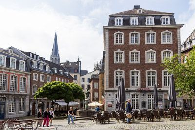Aachener Altstadt mit Ziegelsteingebäuden, Plätzen und der Pfarrkirche St. Foillan im Hintergrund.