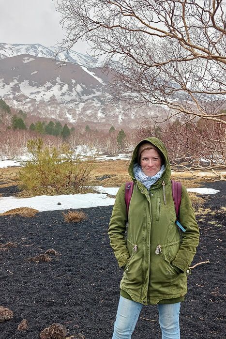 Frau bei einer Ätna-Tour blickt über die kontrastreiche Landschaft.