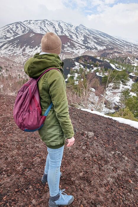 Frau bei einer Ätna-Tour blickt über die kontrastreiche Landschaft.
