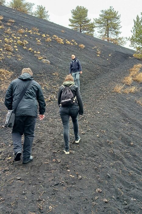 Anstrengender Anstieg bei der Ätna-Wanderung Eine Kleingruppe wandert auf den Ätna, der Weg geht steil aufwärts und besteht aus Aschgranulat.