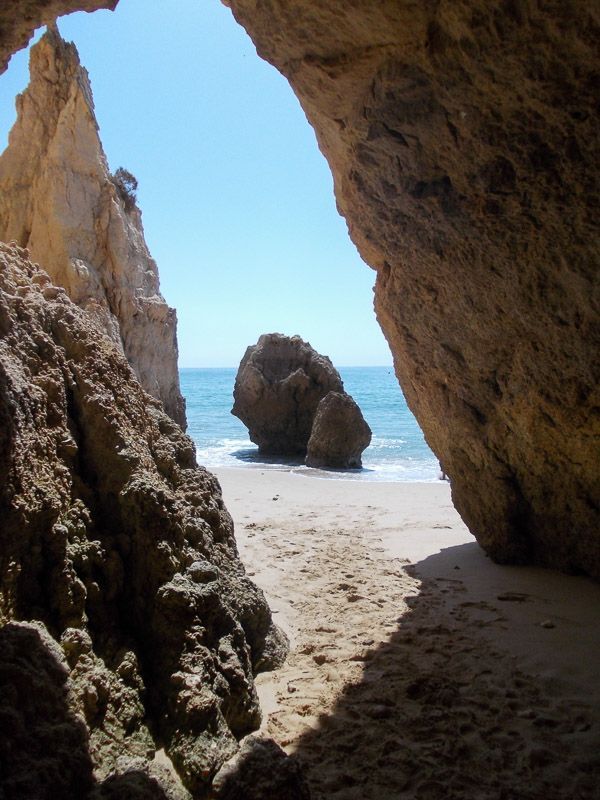 Nimm dir Zeit, die Strände und Buchten zu erkunden Blick von einem unterhöhlten Felsen auf einen Strand an der Algarve.