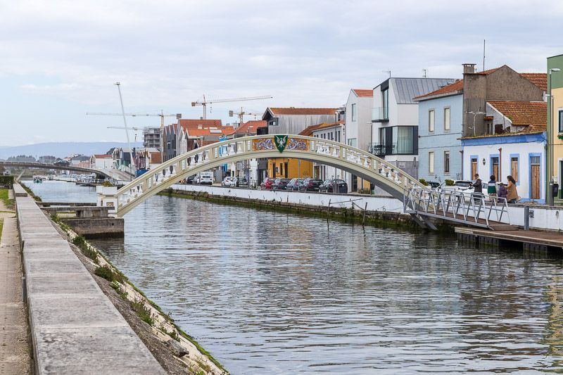 Die weiße Bogenbrücke Ponte dos Carcavelos in Aveiro mit buntem Emblem.