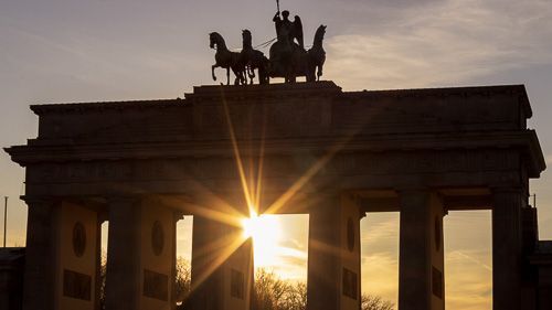 Umrisse des Brandenburger Tors bei tiefstehender Sonne.
