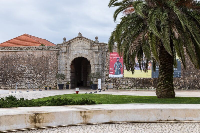 Eingang zum alten Fort in Cascais, Portugal Neben dem Eingang zur Zitadelle von Cascais steht eine große Palme.