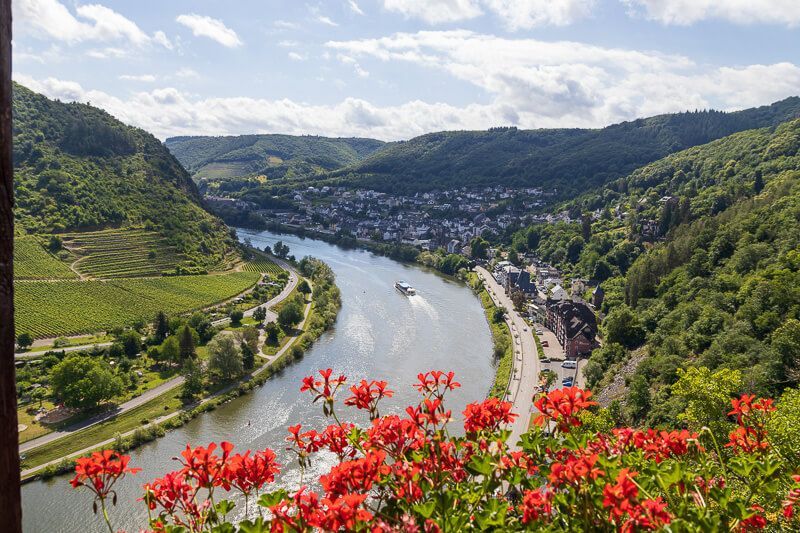 Was für eine tolle Aussicht von der Reichsburg Cochem Weiter Blick über das Moseltal bei Cochem von einem Balkon aus mit Blumen.
