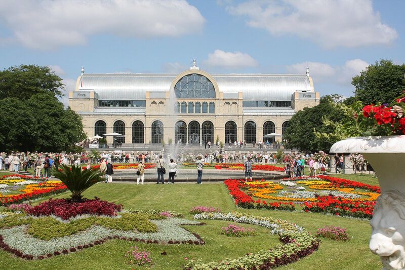 Die Festhalle Flora in Köln mit kunstvollen Blumenbeeten.