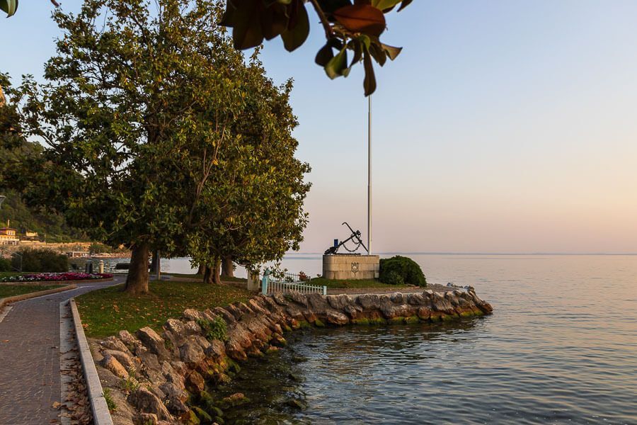 Sehenswürdigkeit Garda: Monumento ai Marinai e ai Pescatori Seepromenade in Garda mit Blick auf den Gardasee und das Monumento ai Marinai e ai Pescatori.
