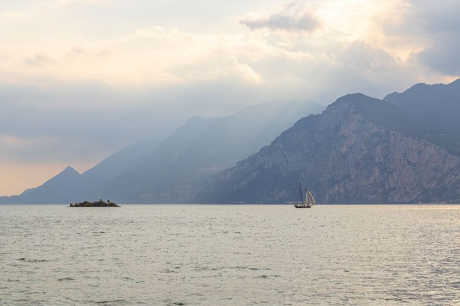 Segelschiff auf dem Gardasee. Segelschiff auf dem Gardasee bei Malcesine. Die Bergkette des anderen Ufers liegt mystisch hinter Wolken.