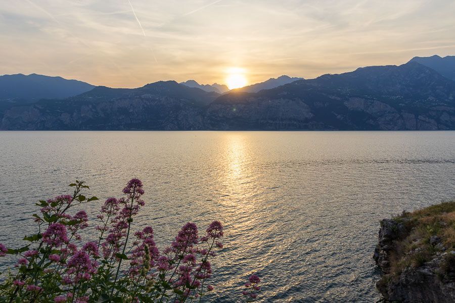 Sonnenuntergang in der Bucht Spiaggia di Posterna in Malcesine. Sonnenuntergang am Spiaggia di Posterna in Malcesine mit Blick auf den Gardasee.