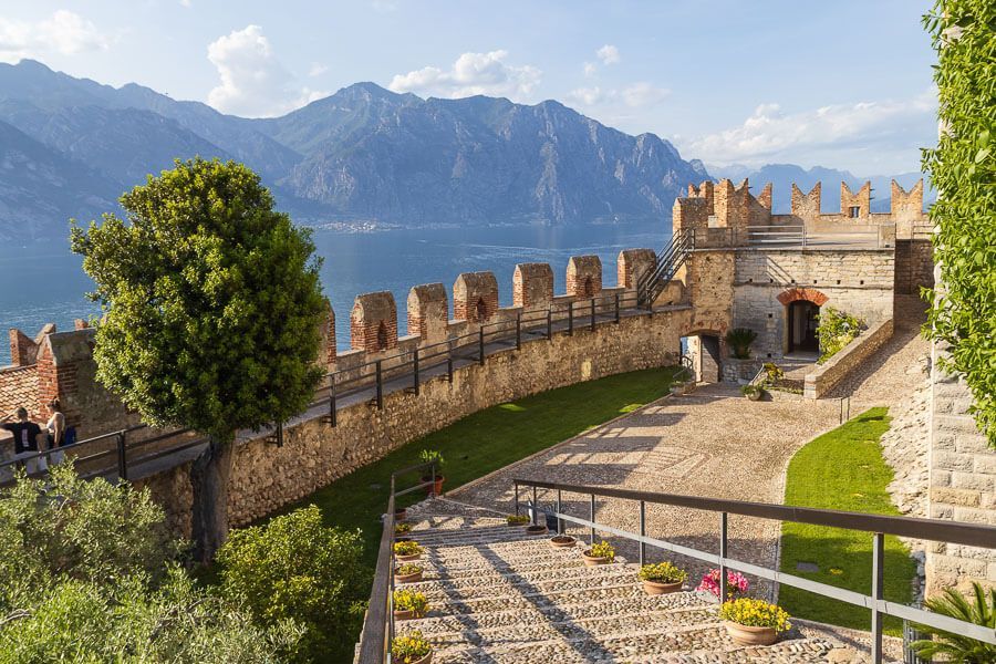Innenhof der Scaligerburg von Malcesine. Innenhof der Scaligerburg von Malcesine, im Hintergrund sind der Gardasee und Berge zu sehen.