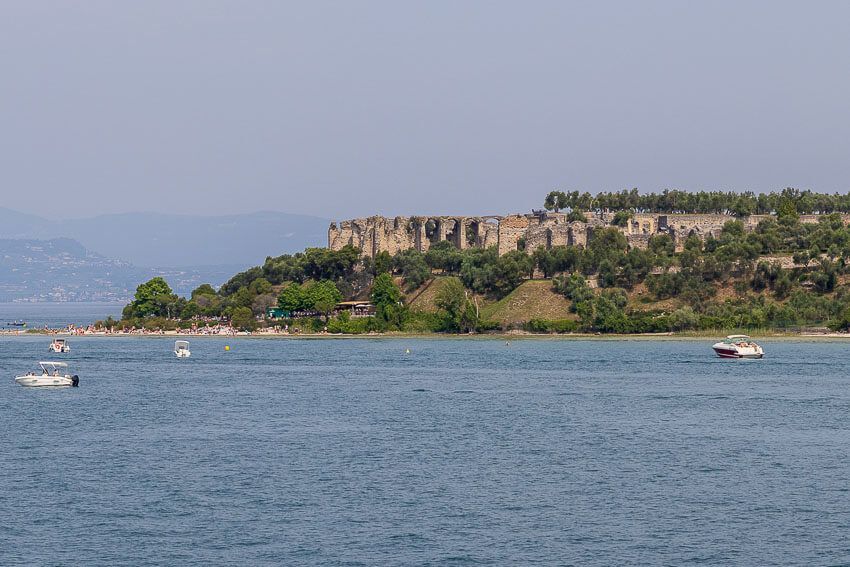 Fast da: Die Fähre fährt einmal um die Halbinsel herum, um in Sirmione anzulegen. Blick von der Fähre auf die Grotten des Catull.