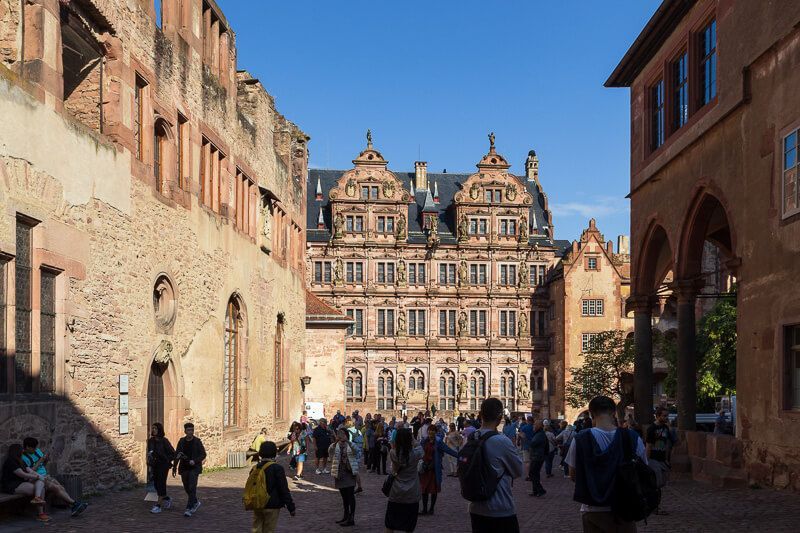 Top-Sehenswürdigkeit: Bereits früh am Morgen ist Schloss Heidelberg gut besucht. Der gut besuchte Schlosshof vom Heidelberger Schloss am frühen Morgen bei Sonnenschein.