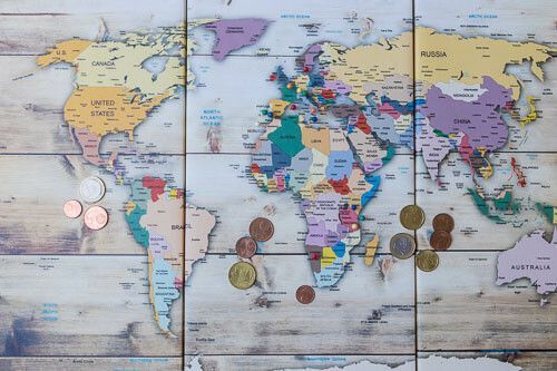 Weltkarte mit ein paar Euromünzen.