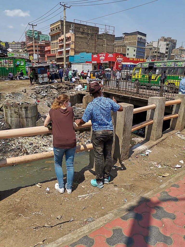 Mein Guide und ich stehen in Nairobi Downtown an einer Brücke, deren Unterführung total zugemüllt ist.