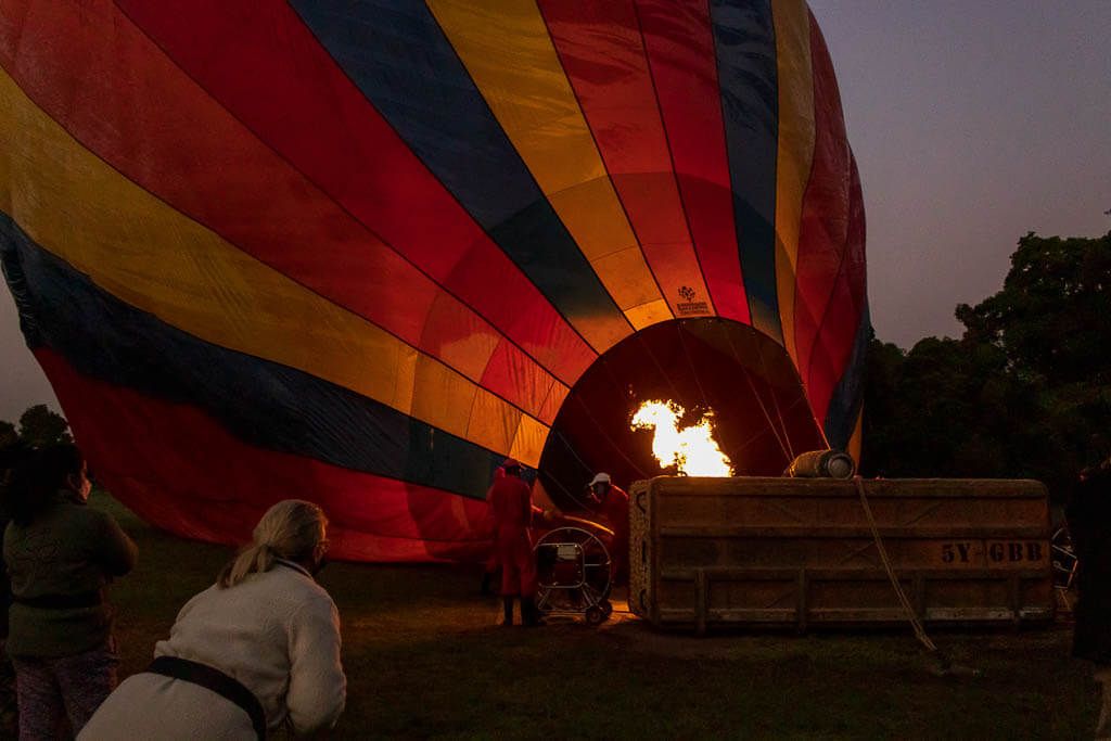 Der Heißluftballon wird vorbereitet. Ein Heißluftballon wird im Morgengrauen für die Fahrt vorbereitet. Eine Flamme erhellt die Dunkelheit.