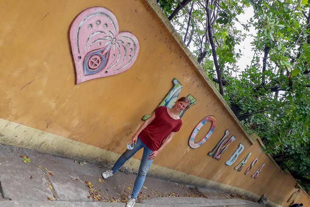 Stadttour in Mombasa: Katrin vor einer Mauer mit dem bunten Schriftzug der Stadt