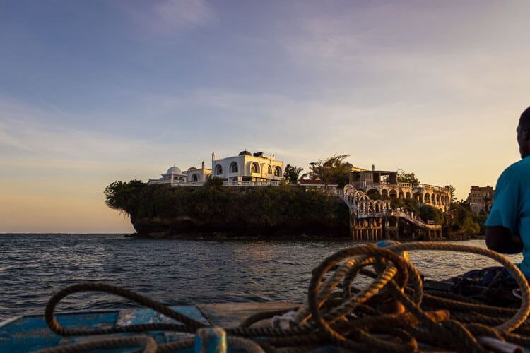 Bootstour in den Sonnenuntergang in Mombasa. Bootstour in Mombasa bei Sonnenuntergang. Der Blick geht auf weiß getünchte Gebäude mit Bogenfenster und kleinen Kuppeln.