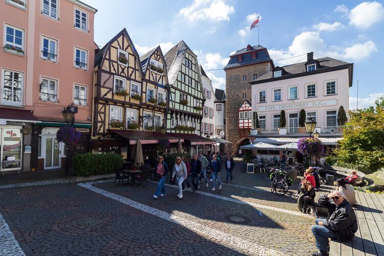 Burgplatz in Linz am Rhein mit dem Rheintor im Hintergrund Burgplatz in Linz am Rhein mit dem Rheintor und viel buntem und prächtigem Fachwerk. Menschen genießen das schöne Wetter.