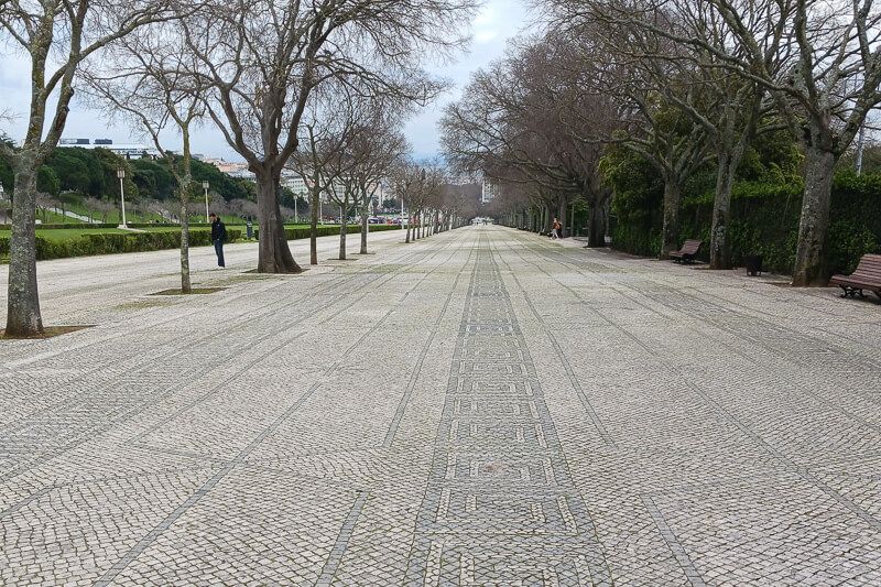Allee im Parque Eduardo VII, Lissabon Parque Eduardo VII mit breiter Allee und kunstvollem Straßenpflaster.
