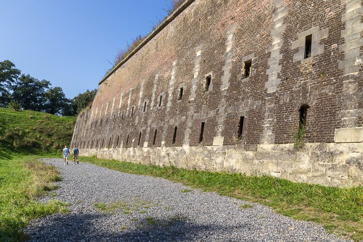 Schotterweg, der um das Fort führt Schotterweg, der um das mächtige Fort Sint Pieter führt. Zwei Männer laufen den Weg lang.
