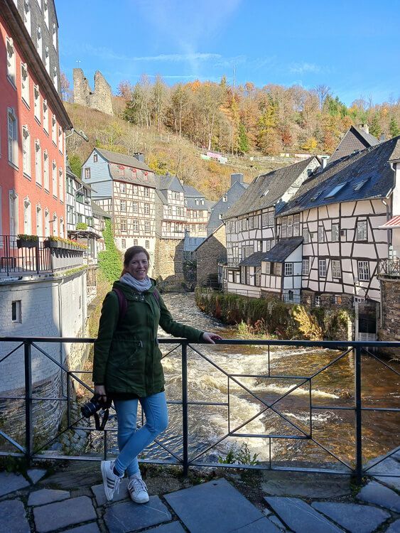 Ein Tag in Monschau. Ein Frau steht in der Altstadt von Monschau und posiert für ein Foto.