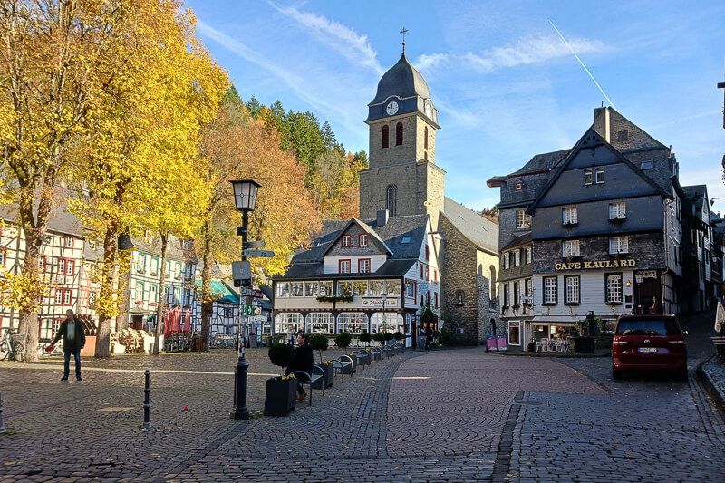 Bei einem Spaziergang durch Monschau kommt man am Marktplatz vorbei. Marktplatz in der Altstadt von Monschau mit Kirche und viel Fachwerk.