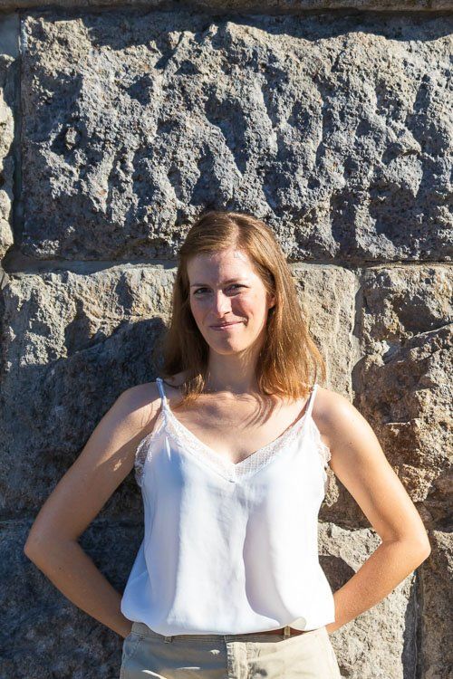 Sommersonnenmädchen vor Steinwand im Sonnenlicht