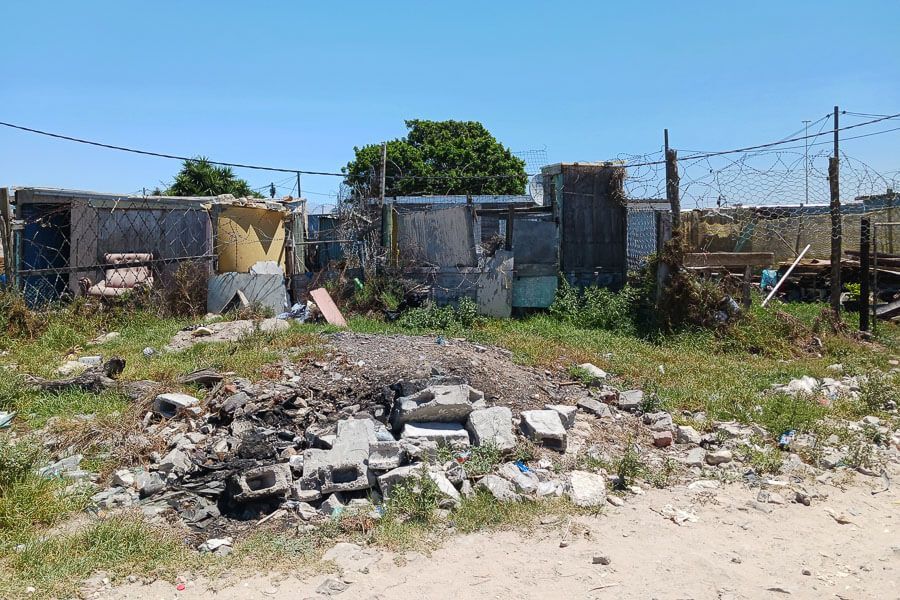 Aschereste: Die Bewohner verbrennen ihren Müll, hier sind Überreste zu sehen Aschereste, im Hintergrund sind Wellblechhütten zu sehen.