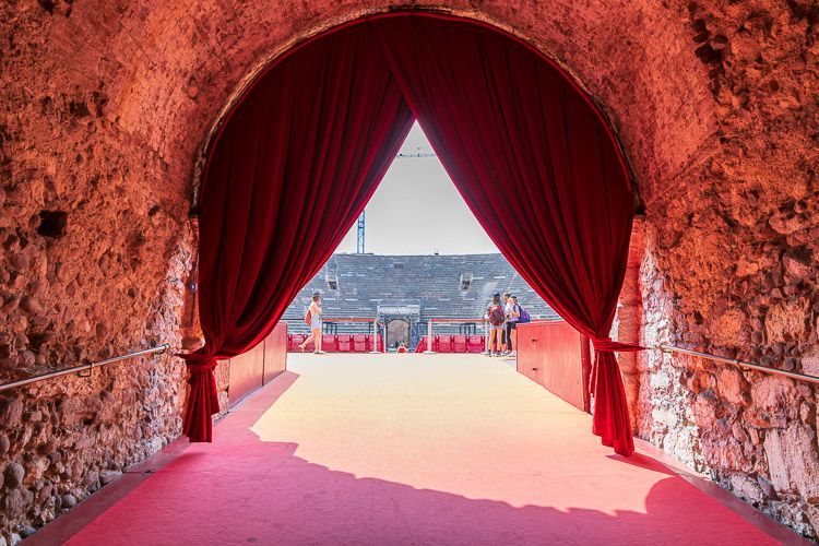 Durchgang zum Zuschauerraum der Arena di Verona. Vor dem Haupteingang in den Zuschauerraum der Arena von Verona. hängt ein roter schwerer Samtvorhang.