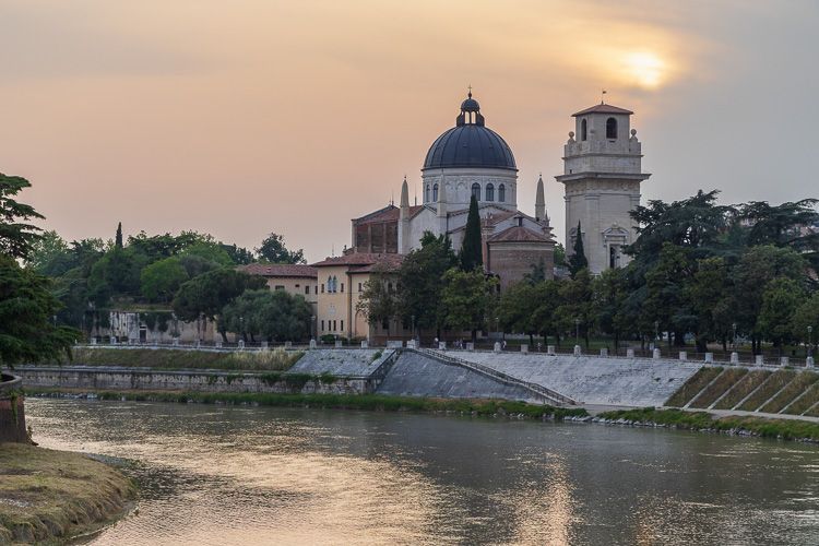 Sonnenuntergang in Verona. Blick von der Ponte Pietra auf eine Kirche bei Sonnenuntergang.