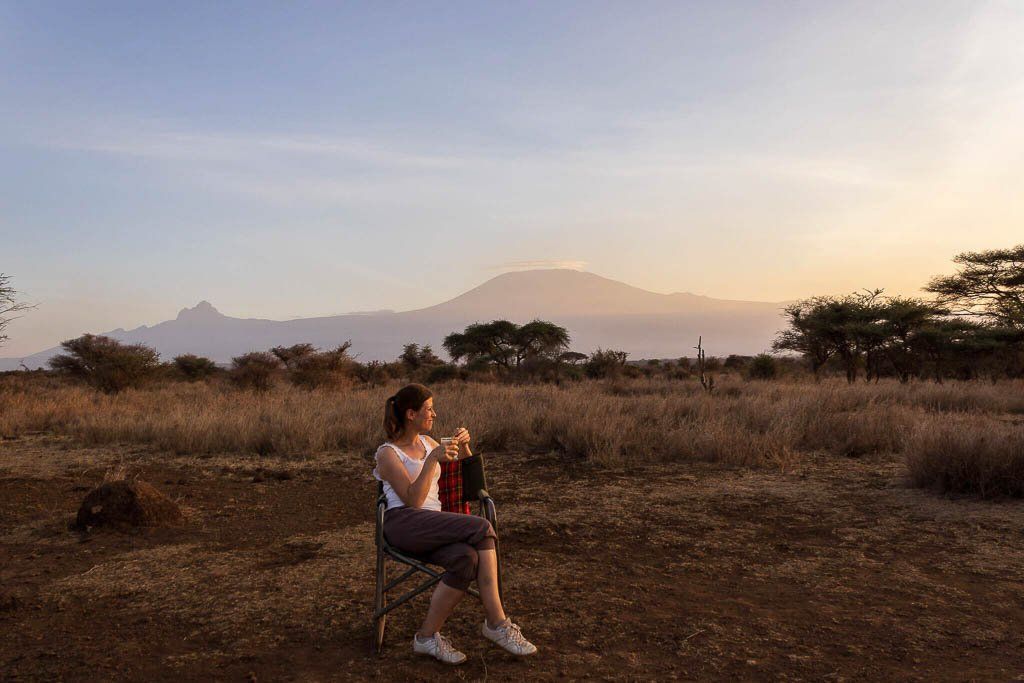 Ein Grund, das Reisen zu lieben: Sundowner mitten im Amboseli. Im Hintergrund thront der Kilimandsscharo Sundowner mitten im Amboseli. Im Hintergrund thront von der Sonne beschienen der Kilimandscharo.