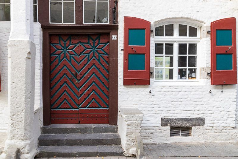 Es gibt viele Details in Zons zu entdecken Kunstvolle, rot-blaue Fensterläden und Tür in der Zonser Altstadt.