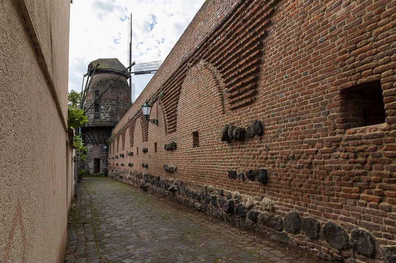 Weg entlang der Zonser Stadtmauer Historische Stadtmauer mit der über 600 Jahre alten Windmühle in Zons.