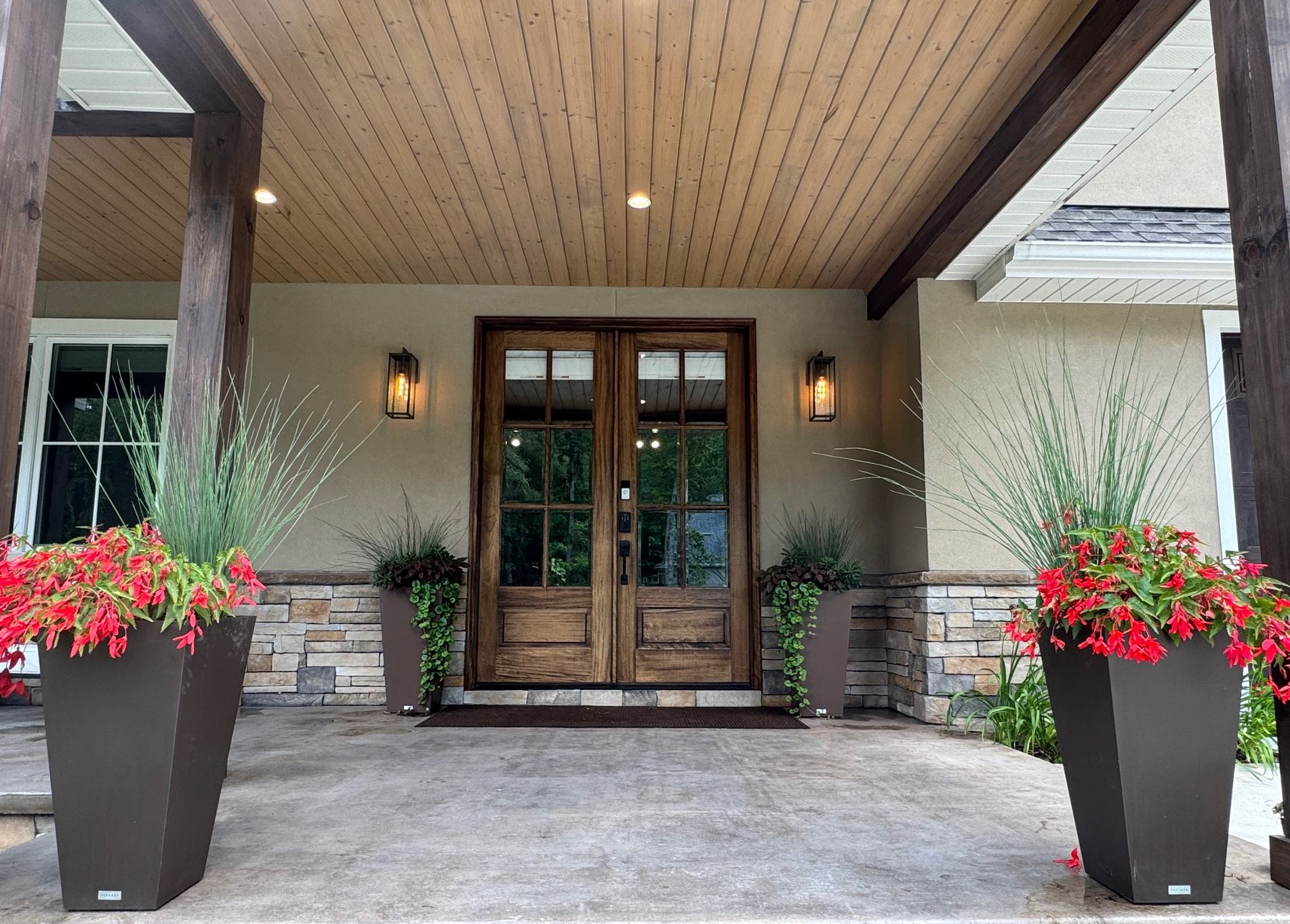 Gentleman’s retreat exterior with colorful planters and outdoor lighting.