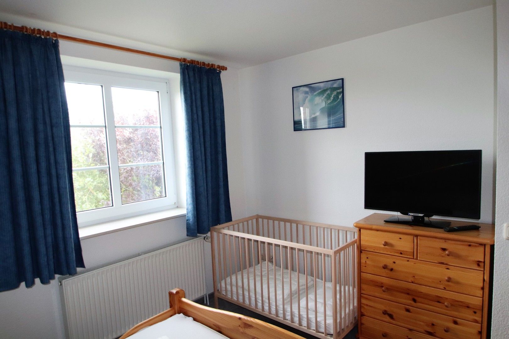 Schlafraum mit Doppelbett und Babybett im Obergeschoss Ferienhaus Queller 24c Nordsee Friedrichskoog