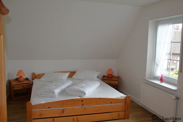 Schlafraum mit Doppelbett und Kinderbett im Obergeschoss Ferienhaus Buschsand 9 Nordsee Friedrichskoog