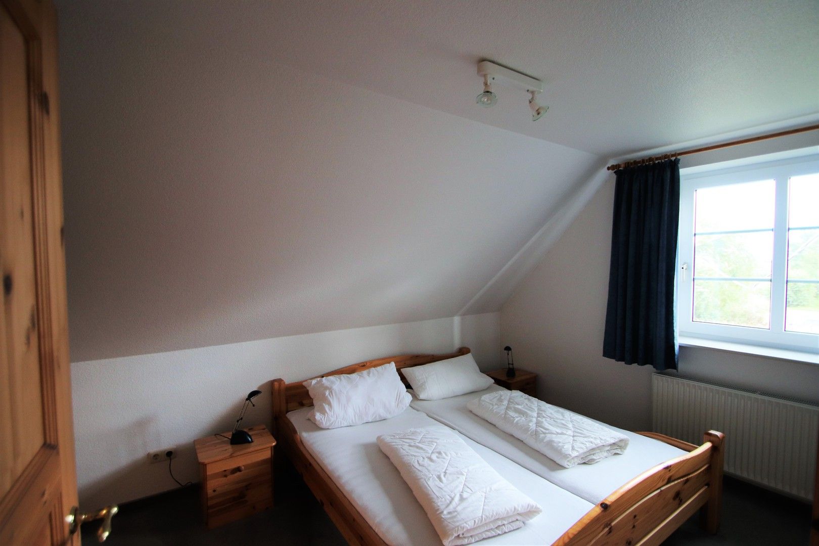 Schlafraum mit Doppelbett im Obergeschoss Ferienhaus Queller 24c Nordsee Friedrichskoog