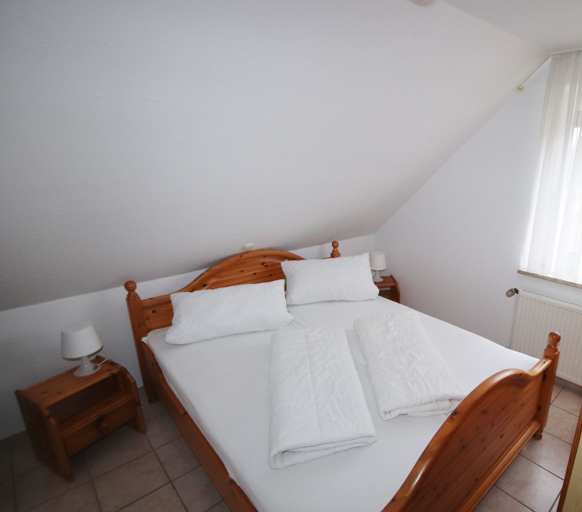 Schlafraum links mit Doppelbett im Obergeschoss Ferienhaus Tötel 1a Nordsee Friedrichskoog
