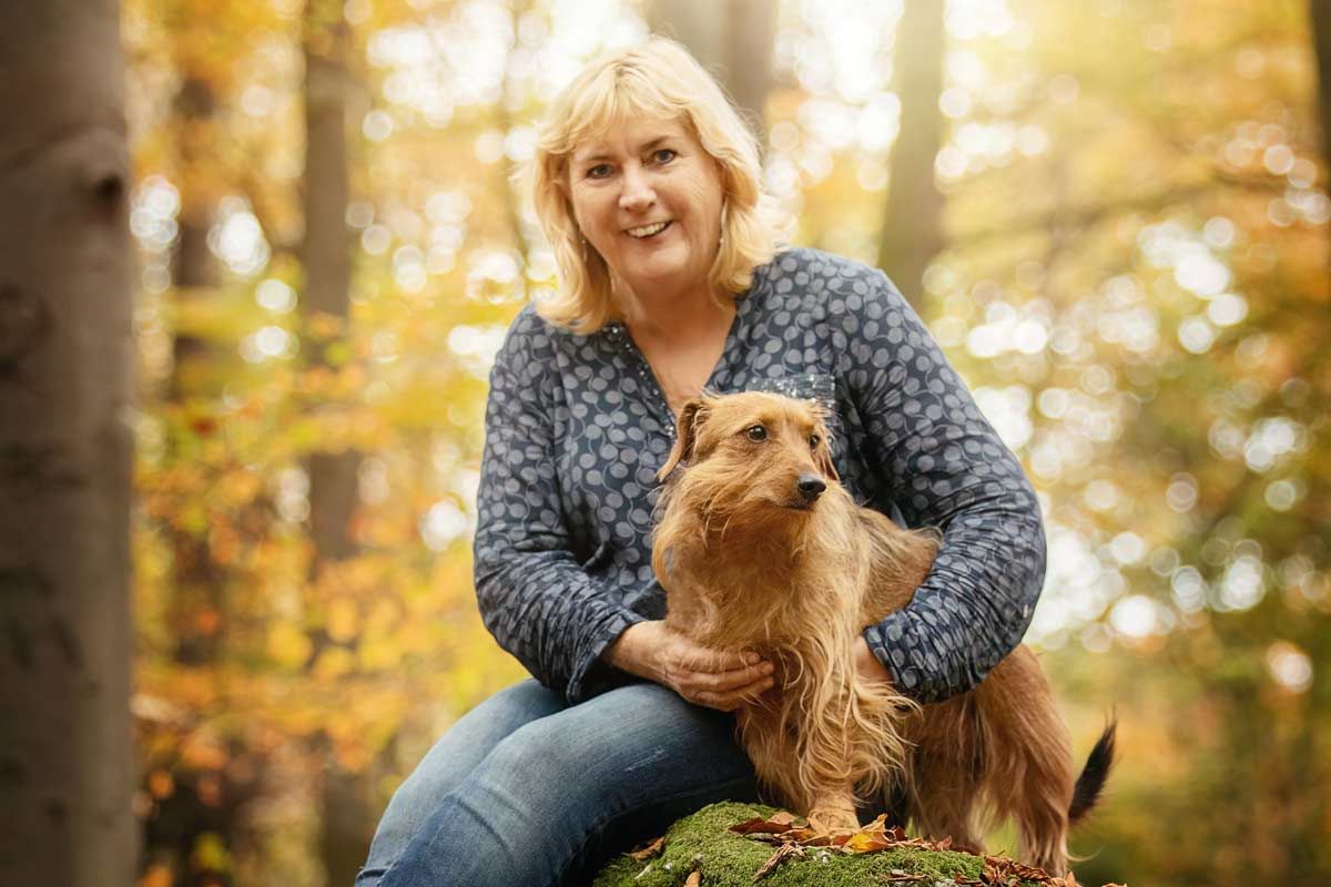 LL Photography Mensch und Tier: Kleiner rotbrauner Mischlingshund mit Frauchen im Herbstwald.