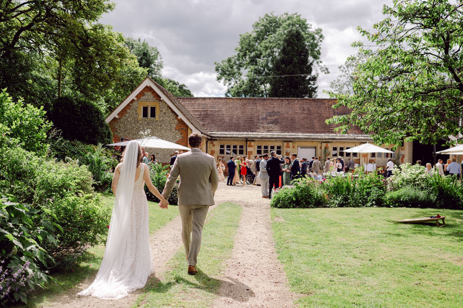 Guests walking back to Kingsettle Stud for drinks reception on the courtyard co-ordinated by Tasha Mae Wedding Co-ordinator.