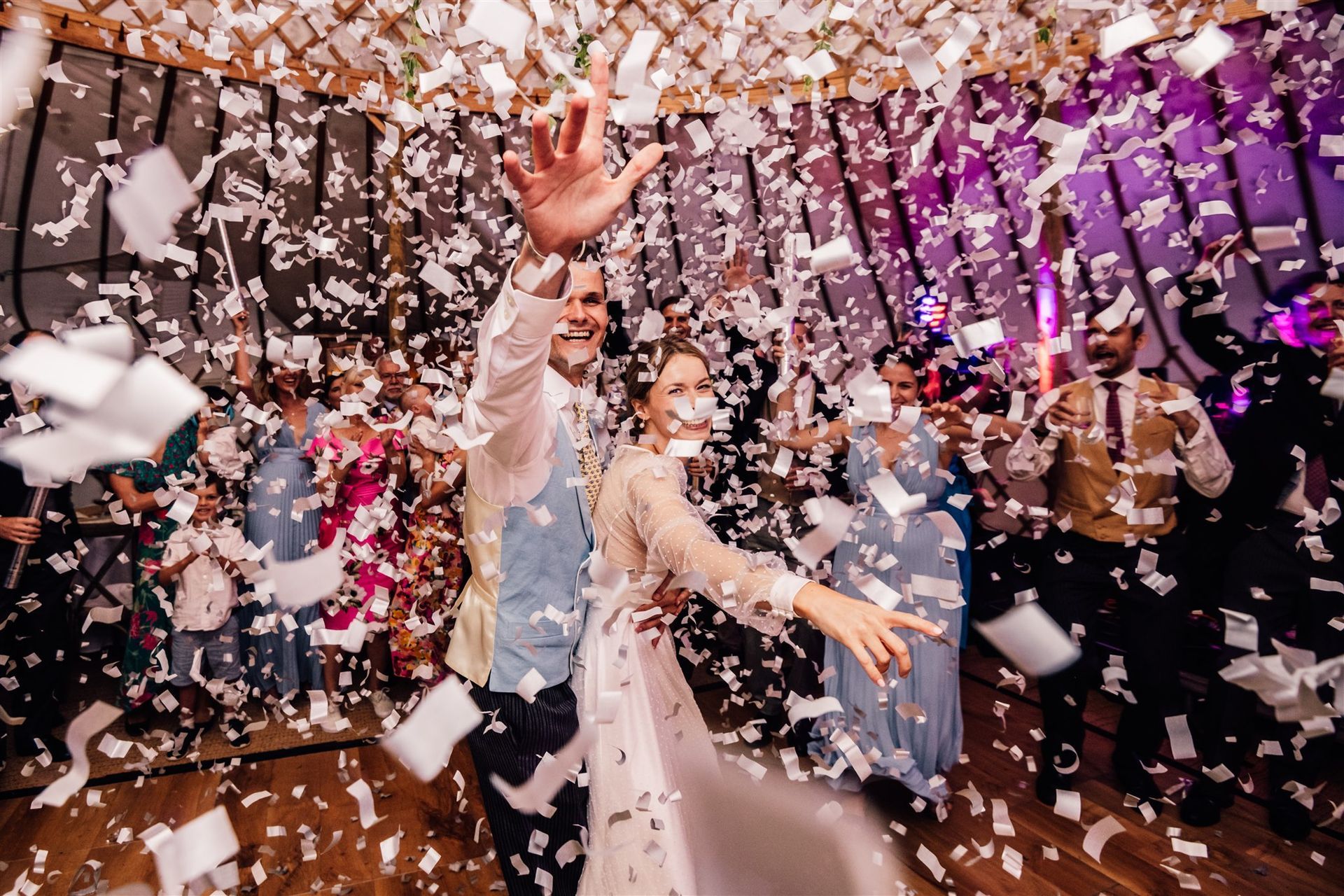 Bride and Groom under a confetti cannon at their wedding at home in Wiltshire coordinated by Tasha Mae Wedding Co-ordinator