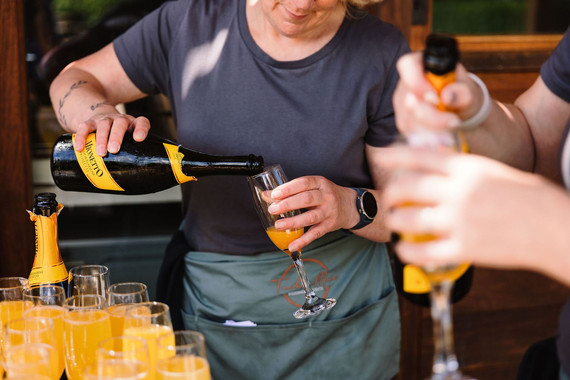 Tasha Mae's Wedding Co-ordinator team pouring drinks at Warborne Farm in Hampshire.