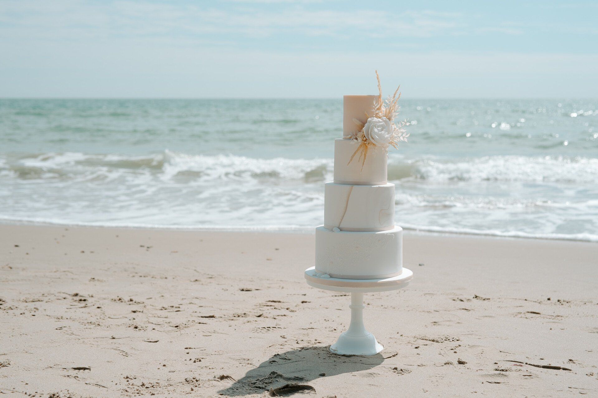 Beach themed wedding cake on the shoreline of Highcliffe Beach in Dorset
