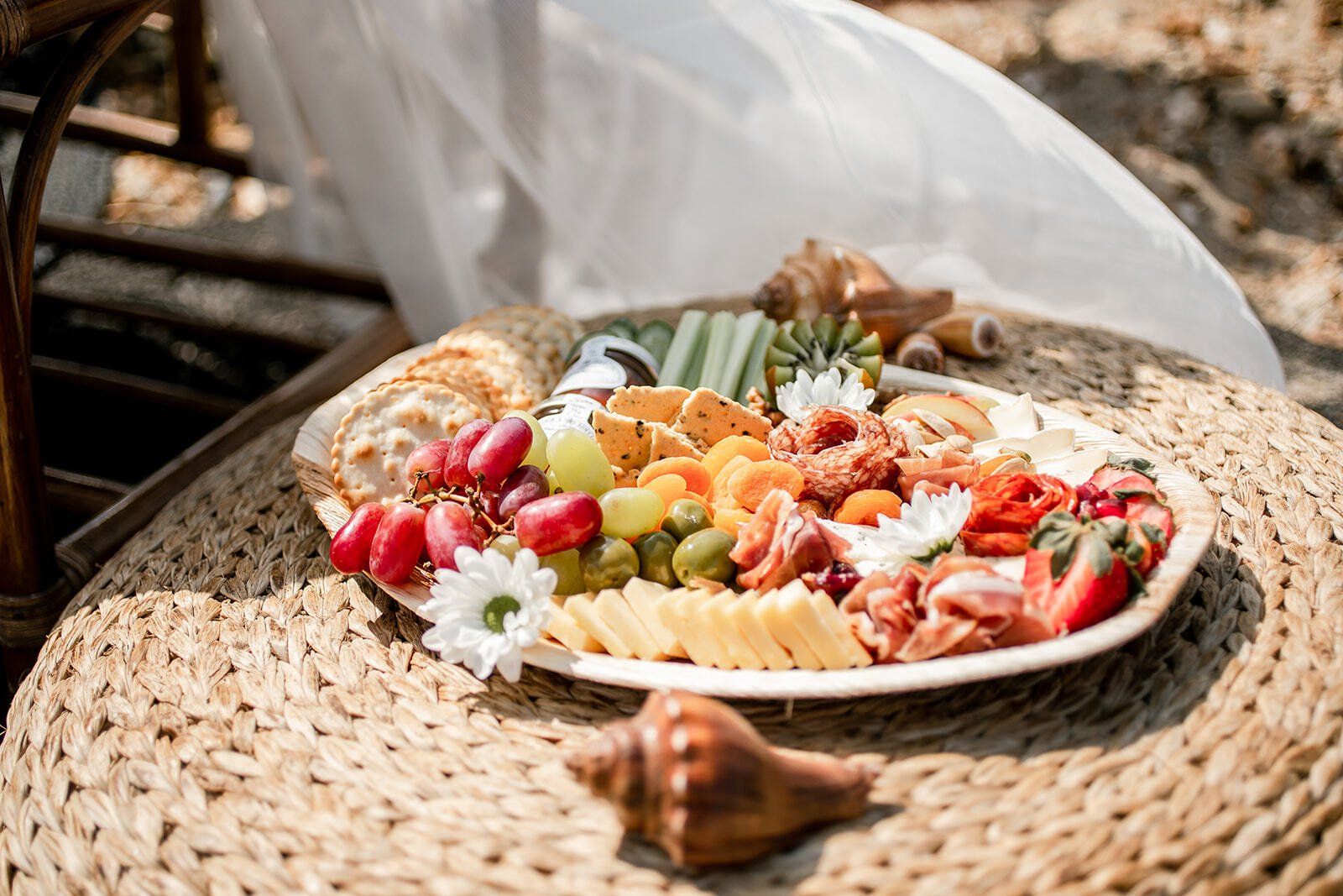 Grazing Platter Picnic on a wicker footstool with seashells decorating it